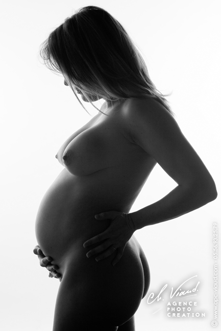 Portrait en noire et blanc artistique d'une femme enceinte en studio photo professionnel