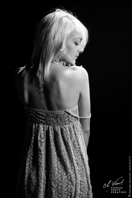 Photo en noir et blanc d'une femme de dos dans un studio professionnel
