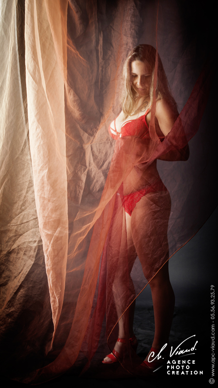 Portrait sexy d'une femme en sous vêtements rouge derrière un voile