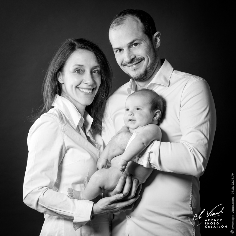 Portrait studio en noir et blanc de parents avec leur nouveau né