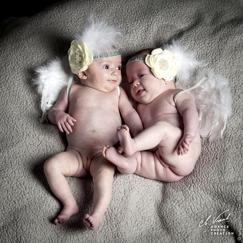 Portrait studio des nouveau-nés avec des ailles d'ange dans un studio photos