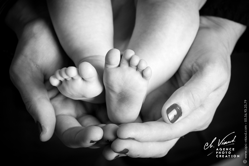 Jolie photo des pieds d'un bébé dans les mains de sa mère pendant une séance photos famille