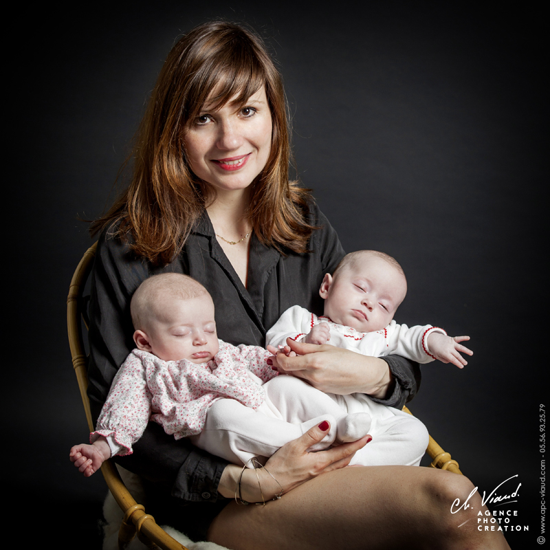 Portrait studio d'une mère avec ses filles dans les bras durant une séance photos famille