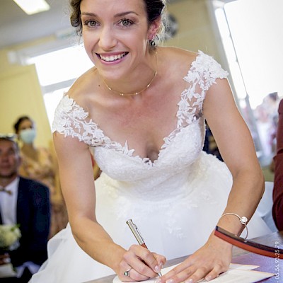 Reportage mariage - Photo de la mariée signant les papiers à la mairie